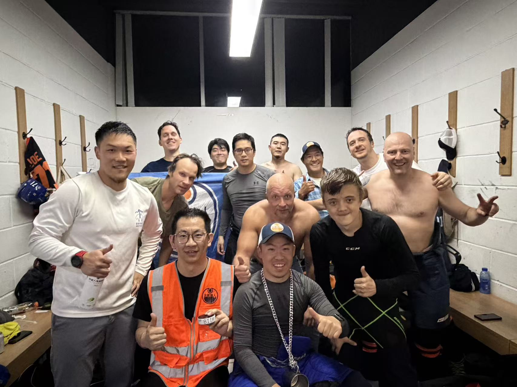 Oilers team posing together in the locker room with their team flag