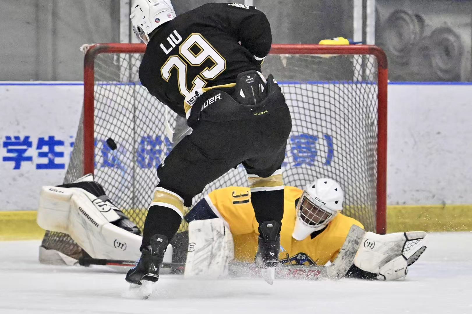 Revs number 29 skating in front of a yellow-jersey goalie