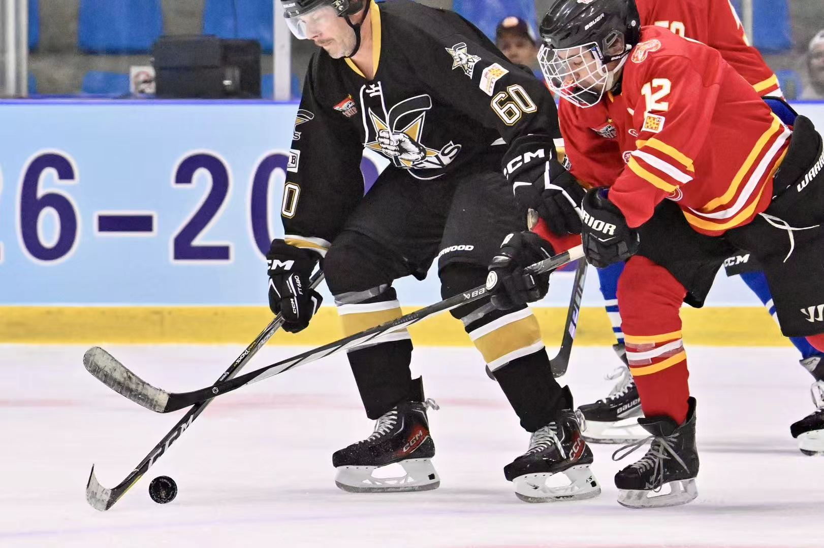 Revs player battling a red-jersey opponent for the puck